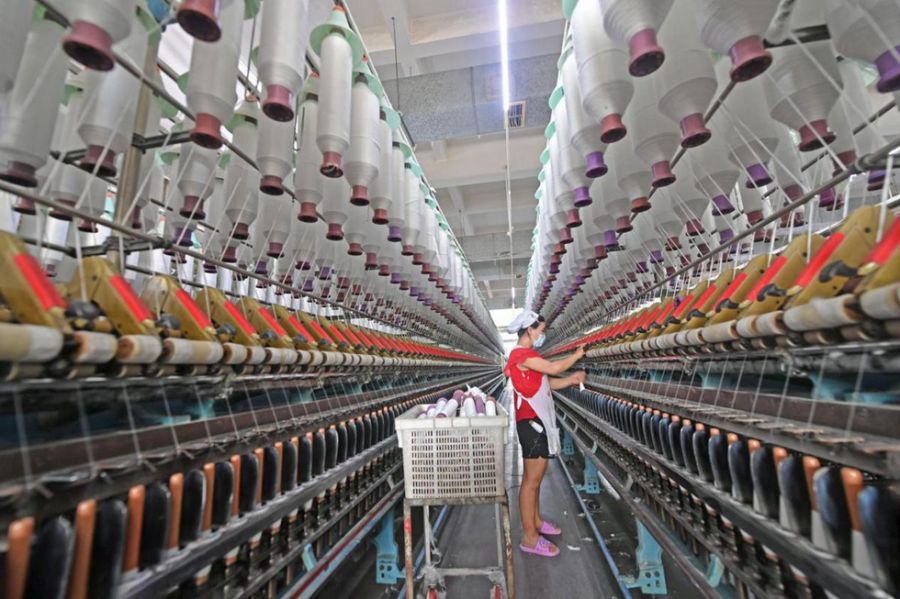 10月8日，在福建省泉州市泉港区山腰街道泉州市博广轻纺有限公司二厂，工人在生产线上忙碌着。（林弘梫 摄）