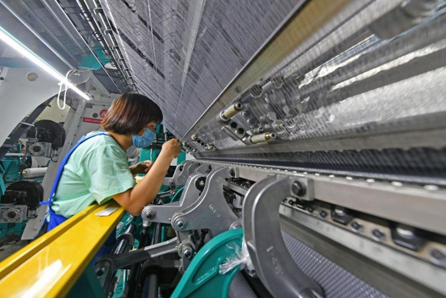 10月8日，在福建省泉州市泉港区山腰街道的福建省安然纺织科技有限公司车间内，工人在生产线上忙碌着。（林弘梫 摄）