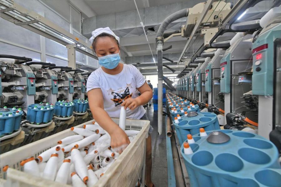 10月8日，在福建省泉州市泉港区山腰街道泉州市博广轻纺有限公司二厂，工人在生产线上忙碌着。（林弘梫 摄）