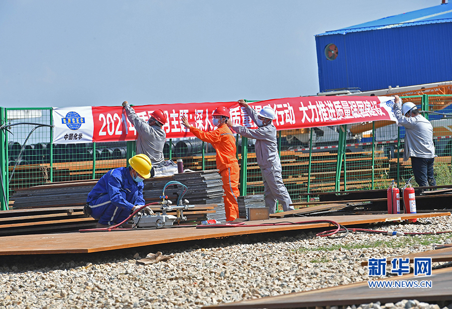 10月19日,在福建省泉州市泉港区福建中燃湄洲湾能源项目现场,工人在悬挂标语。新华网发(林弘梫 摄)