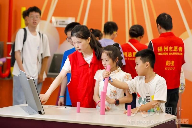8月1日，在福建省福州市鼓楼区的福建省科技馆，安泰街道科技志愿者正在指导孩子们体验科普装置。