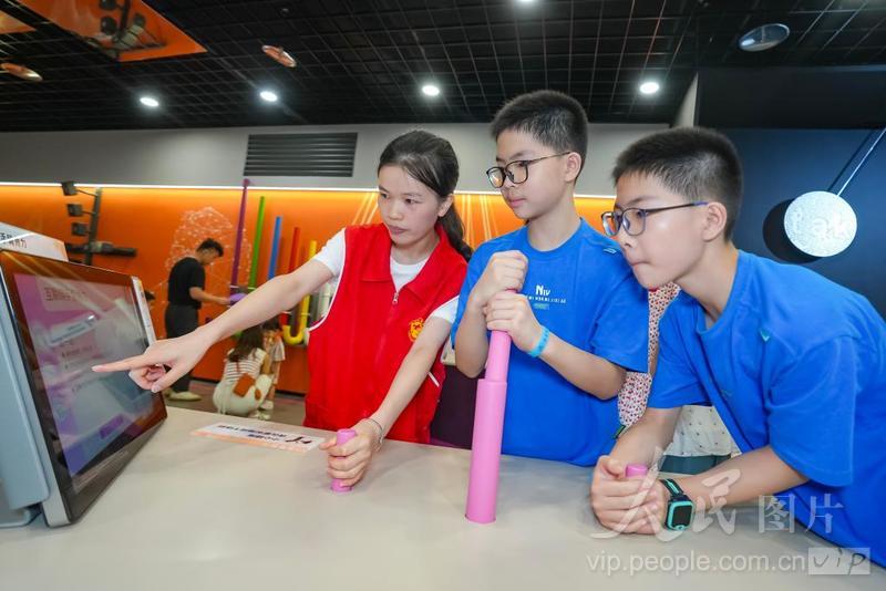 8月1日，在福建省福州市鼓楼区的福建省科技馆，安泰街道科技志愿者正在指导孩子们体验科普装置。