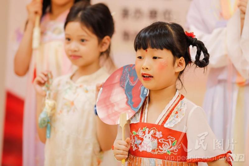 8月8日，七夕节临近，福建省福州市鼓楼区水部街道闽都社区，两岸小朋友身穿汉服，手持漆扇、油纸伞等非遗手工物品，正在进行非遗秀展示。