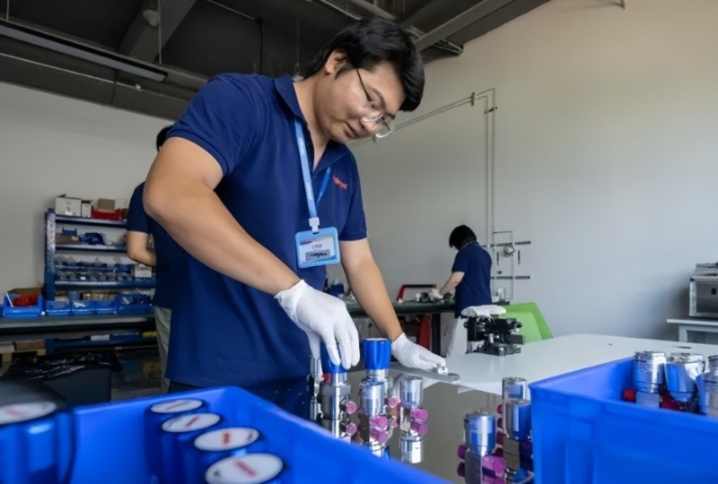 技术人员在企业生产车间内研发产品