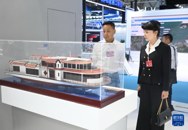 10月16日,与会人员在宁德时代展区观看“闽江会客厅”电动游船模型。新华社记者 林善传 摄