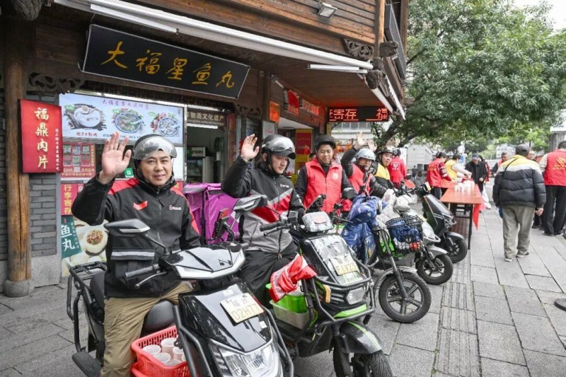 外卖骑手及志愿者送去拗九粥。记者 石美祥 摄