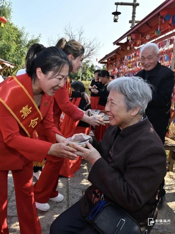 梁厝历史文化街区内，福州喜娘向老年游客送上拗九粥。记者 郑帅 摄