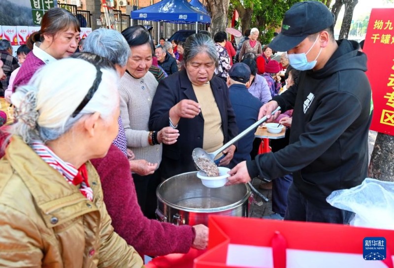 3月17日，在福州市仓山区后巷路，一位餐饮店主（右一）向老人赠送“拗九粥”。新华社记者 林善传 摄