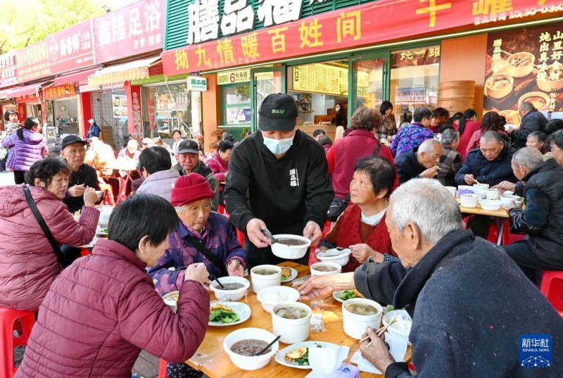 3月17日，在福州市仓山区后巷路，一位餐饮店主（中）为老人送上“拗九粥”。新华社记者 林善传 摄
