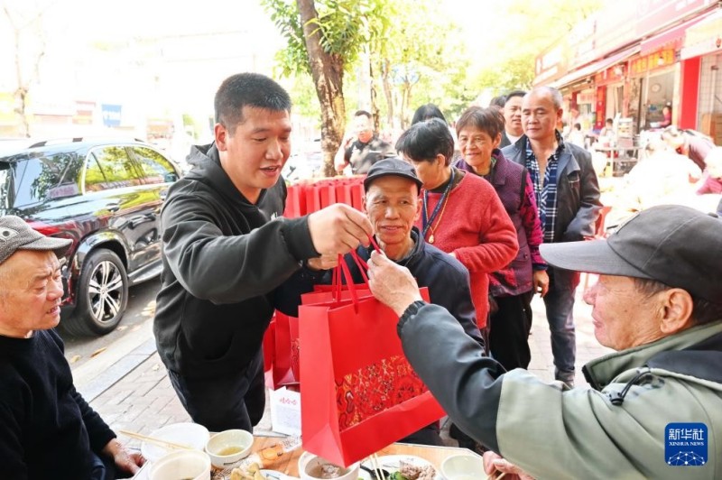 3月17日，在福州市仓山区后巷路，一位餐饮店主（左二）向老人赠送八宝粥、面包等礼品。新华社记者 林善传 摄