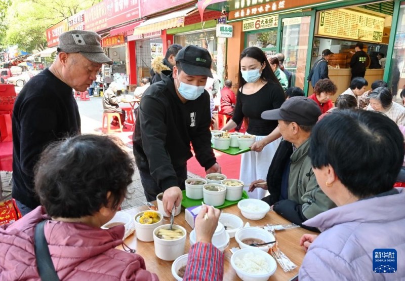 3月17日，在福州市仓山区后巷路，一位餐饮店主（左三）向老人赠送“拗九粥”和炖品。新华社记者 林善传 摄