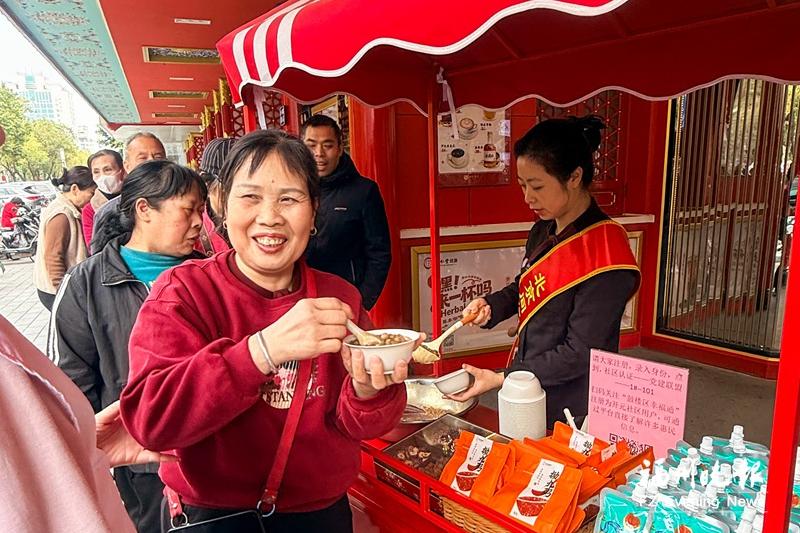 在北京同仁堂福州东街口店门口市民们排队领粥。记者 石美祥 摄