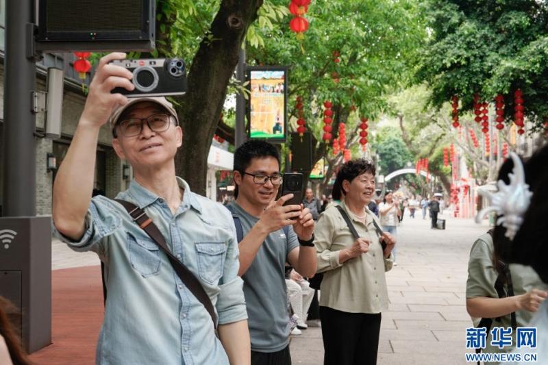 在福州市上下杭历史文化街区，市民游客用手机记录巡游活动。新华网 蒋巧玲 摄