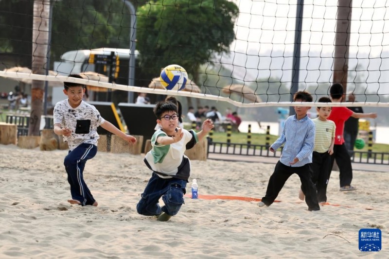 4月11日，小朋友在福建漳州龙江岁月景区玩沙滩排球。新华社记者 姜克红 摄