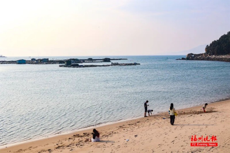 夕阳西下，金色的余晖洒满海岛，将海面染成一片暖橙。