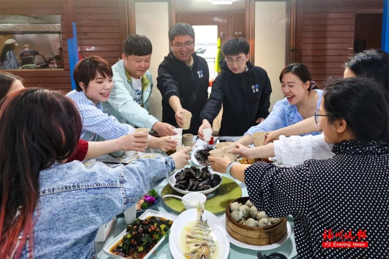 游客们围坐在一起，品尝着现捞现做的海鲜，海风轻拂，烟火氤氲，氛围感拉满。