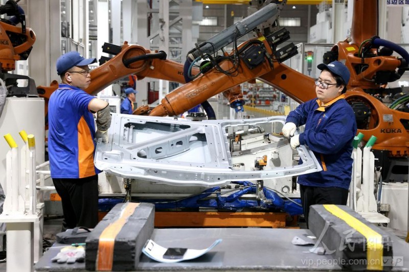 4月16日，在福州荻原泰山友模具冲压有限公司生产车间内，工人配合机器人在生产汽车车身钣金件产品。