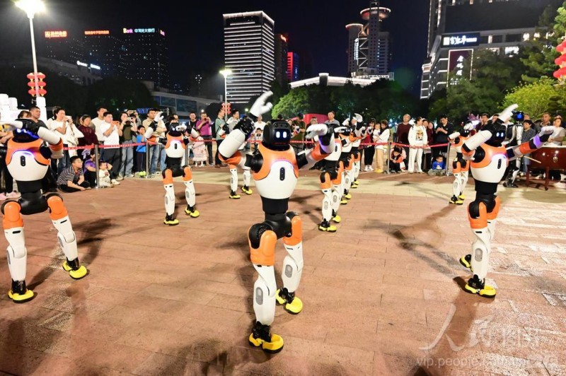 4月19日，在福州五一广场，市民观看机器人表演。