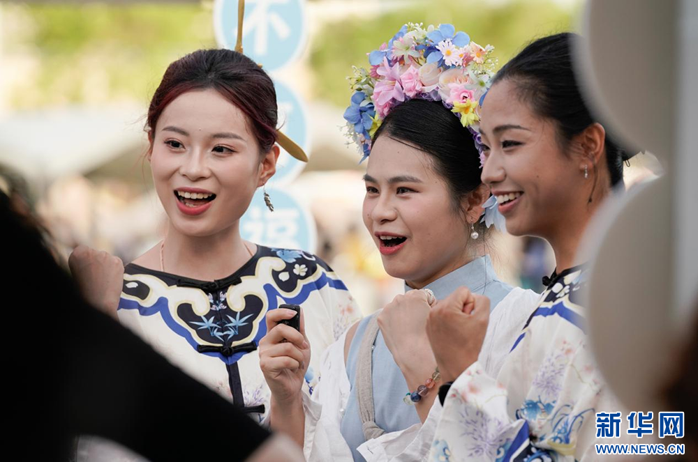 游客在嘉年华活动中体验福州三条簪和泉州簪花围，并为“闽超”加油。新华网 蒋巧玲 摄