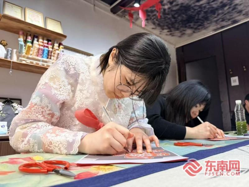 刘智恩与母亲孔恩惠体验漳州剪纸。记者 李景锋 摄