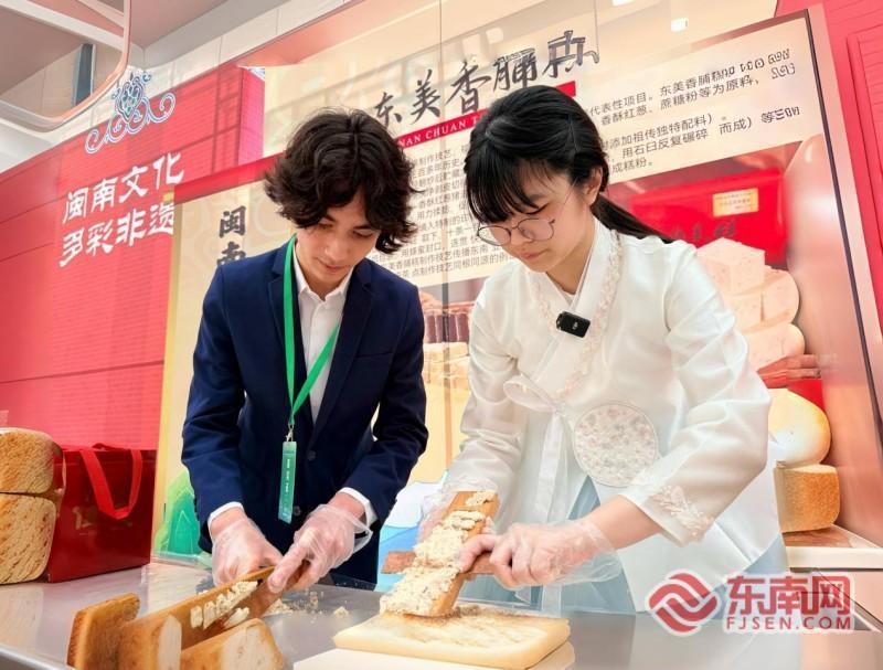 刘智恩与瑞利体验漳州东美香脯糕。记者 李景锋 摄