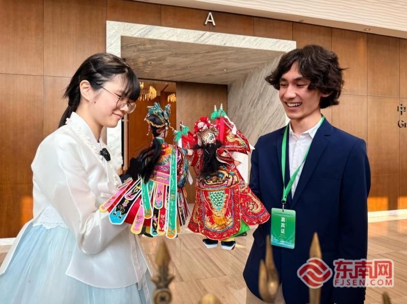 刘智恩与瑞利体验漳州布袋木偶戏。记者 李景锋 摄