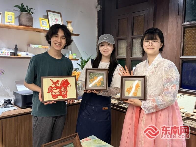 瑞利与刘智恩体验漳州剪纸。记者 李景锋 摄