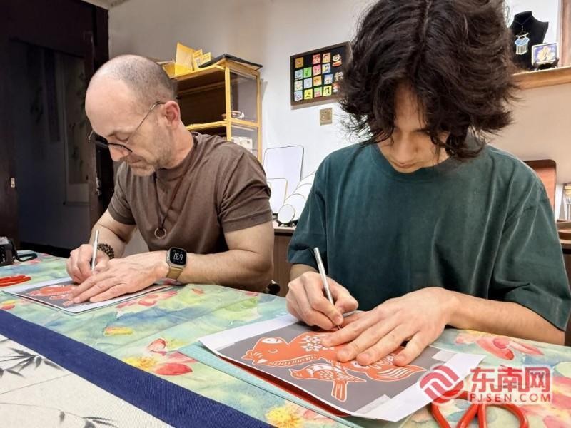 瑞利与父亲查德威克体验漳州剪纸。记者 李景锋 摄