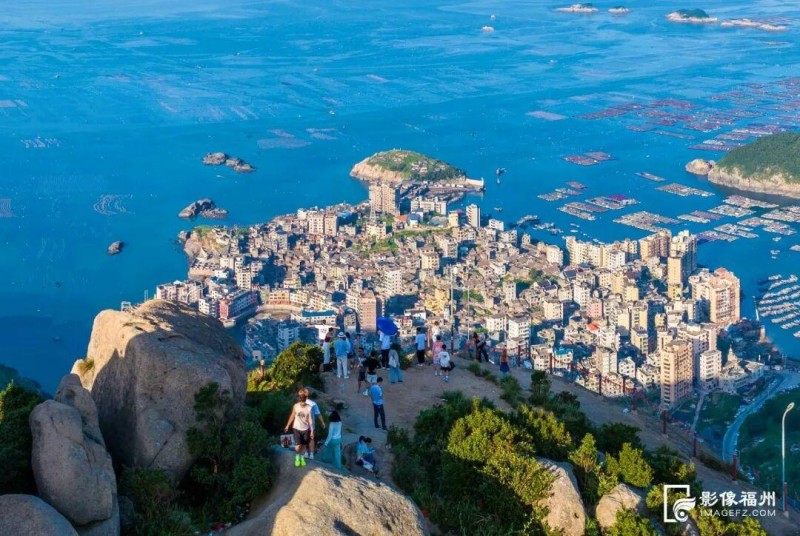 ▲游客登上旗冠顶欣赏奇达村的绝美景色。林双伟/摄