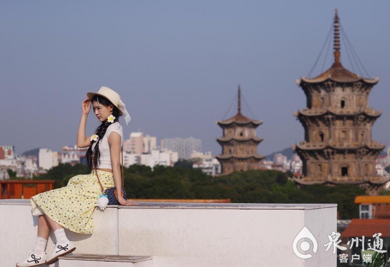 游客坐在甲第巷口的宝藏天台上，打卡东西塔。