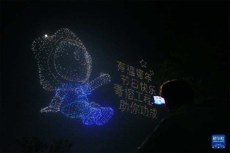 4月28日晚，游客在福州闽侯旗山湖公园拍摄“福聚榕城·数字领航”主题无人机集群光影秀。新华社记者 高咏薇 摄
