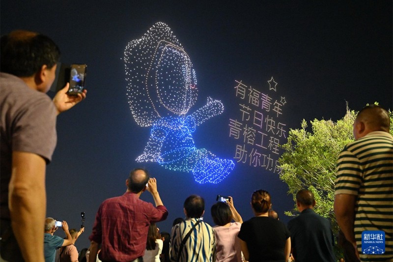 4月28日，游客在观赏拍摄无人机集群光影秀。新华社记者 林善传 摄