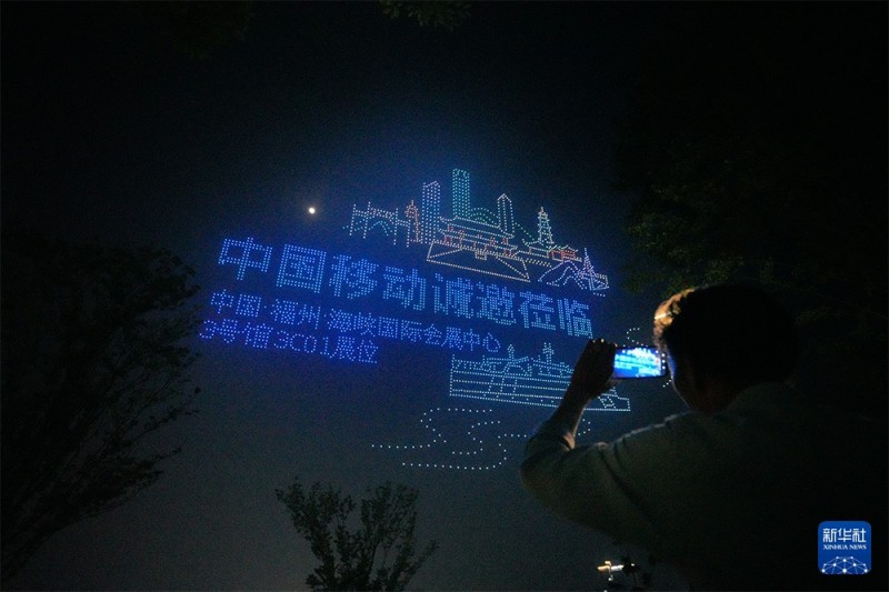4月28日晚，游客在福州闽侯旗山湖公园拍摄“福聚榕城·数字领航”主题无人机集群光影秀。新华社记者 高咏薇 摄