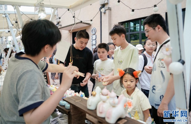 游客在摊位上选购小商品。新华网 蒋巧玲 摄
