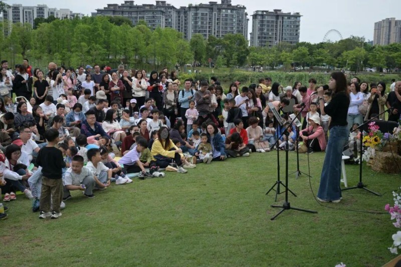 不少市民携家人前来，在草坪上静坐聆听，用音乐定格美好时光，以歌声传递感恩与祝福。