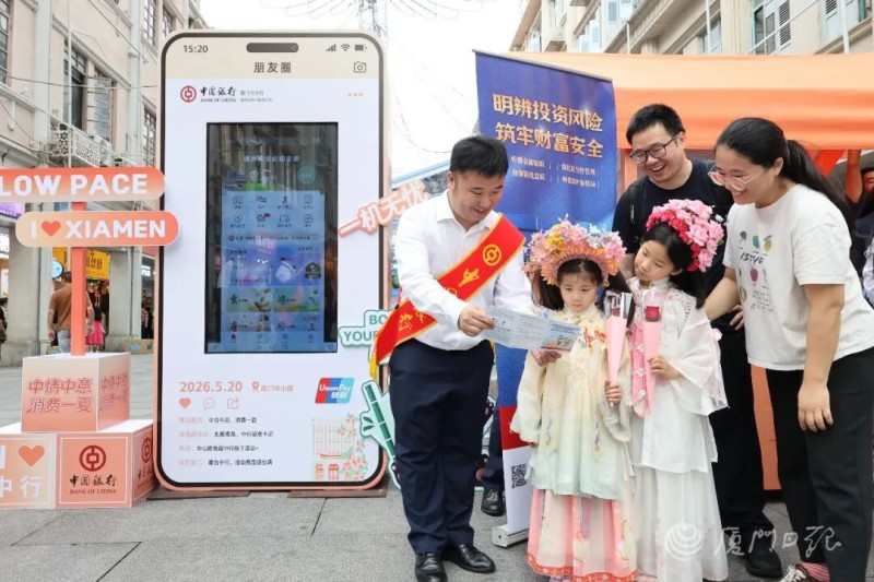 工作人员为来往市民游客普及金融知识。