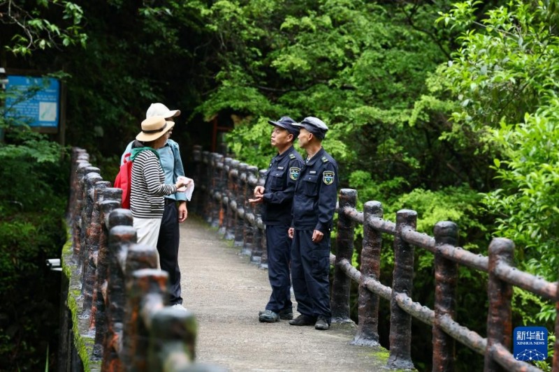 5月8日，武夷山国家公园福建桐木保护站护林员罗贤华（右二）向游客提示注意事项。新华社记者 姜克红 摄