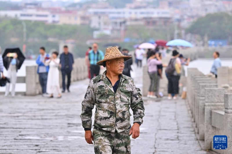 5月15日，在福建泉州，红树林生态协管员刘新民走在洛阳桥上眺望洛阳江面。新华社记者 姜克红 摄