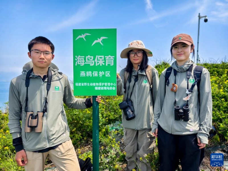 生态保育志愿者谷峥（左一）、岳瑞雪（中）、林可欣（右一）在完成当天常态化人工招引工作后留影（5月12日摄）。新华社记者 魏培全 摄