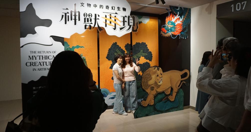 5月21日，在台北故宫博物院的&ldquo;神兽再现&mdash;文物中的奇幻生物&rdquo;特展入口处，参观者和主题展板合影留念。新华社记者褚萌萌摄