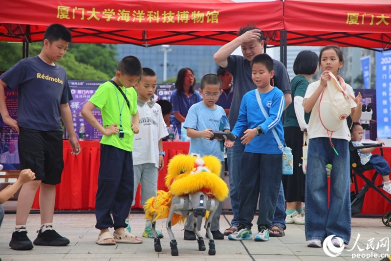 孩子们操作机器狗。人民网记者 陈博 摄