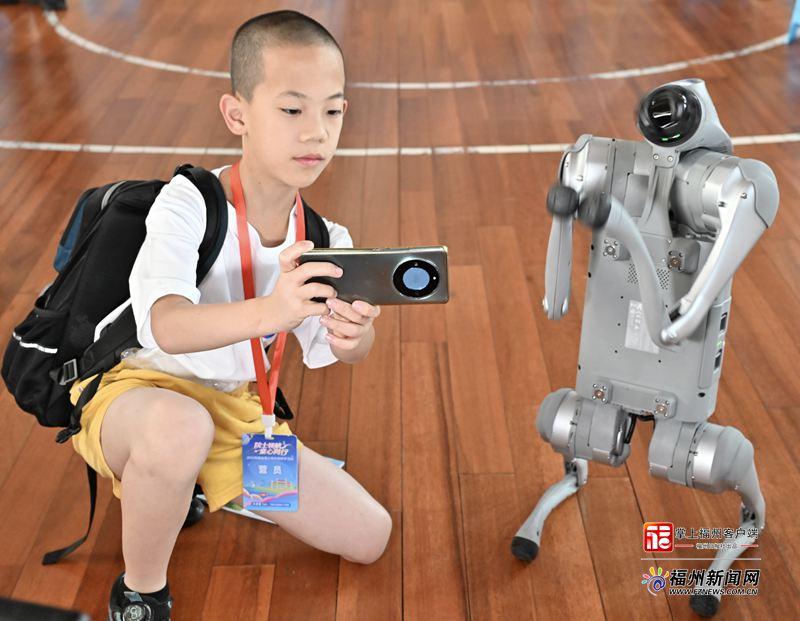 参加榕台青少年科技研学的孩子与福州科技馆的机器狗合影。记者 郑帅 摄