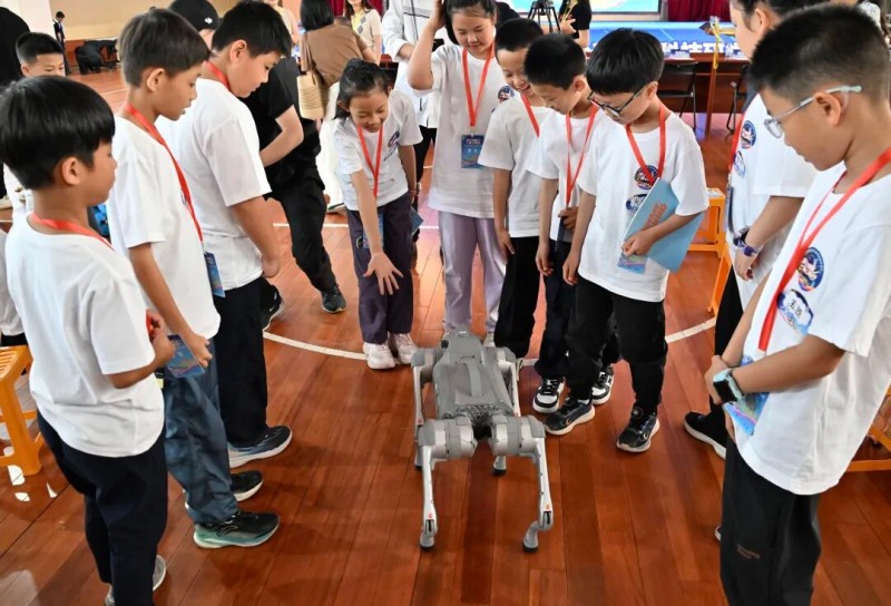参加榕台青少年科技研学的孩子与福州科技馆的机器狗互动。