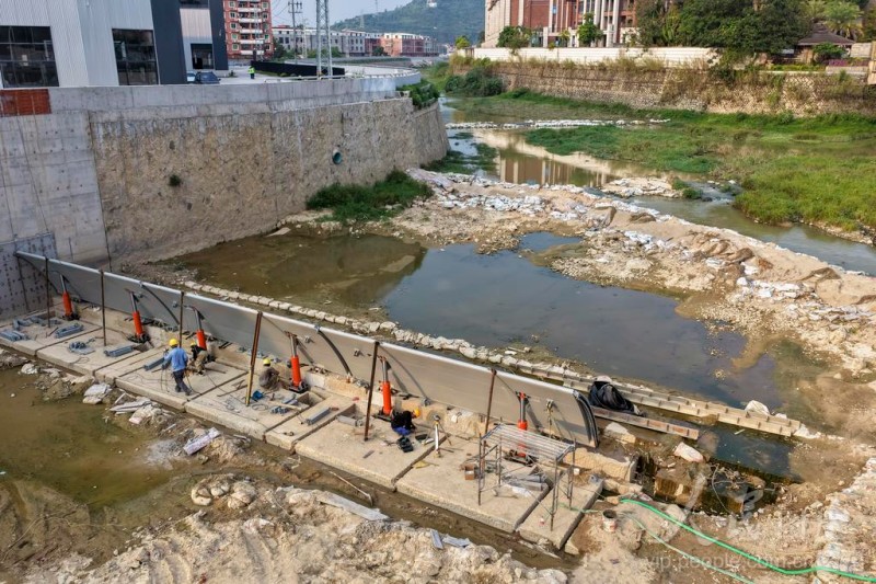 6月2日，福建省南安市洪濑镇梅溪流域，工人正在加紧调试拦水设施。