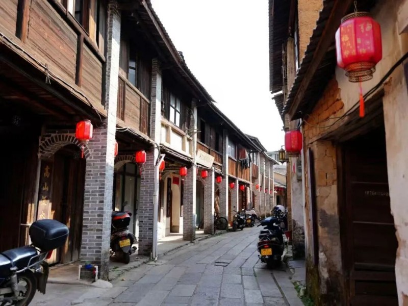 漫步武所古街，夏日柔光穿透街巷，细碎光影洒落青石板路。骑楼古民居沿街排布，墙面镌刻着岁月痕迹，老街之间藏着旧时商贸繁华的印记。古街街巷错落有致，走进街巷，细听街坊邻居闲谈絮语、街巷趣事，交谈此起彼伏，平凡又暖心。