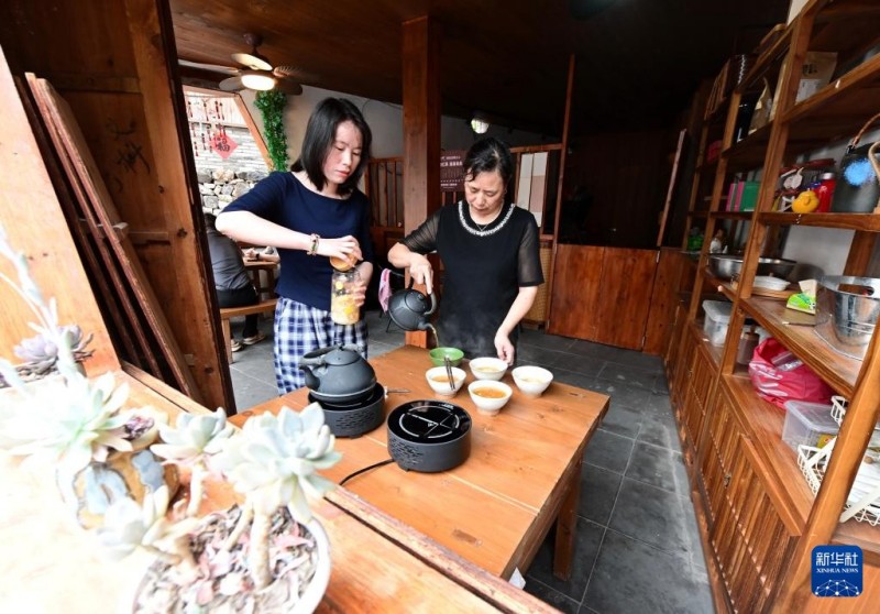 6月5日，村民苏兰梅（左）在寿山村茶盐古街的“共富驿站”经营点为游客制作民间小食蛋茶。新华社记者 林善传 摄