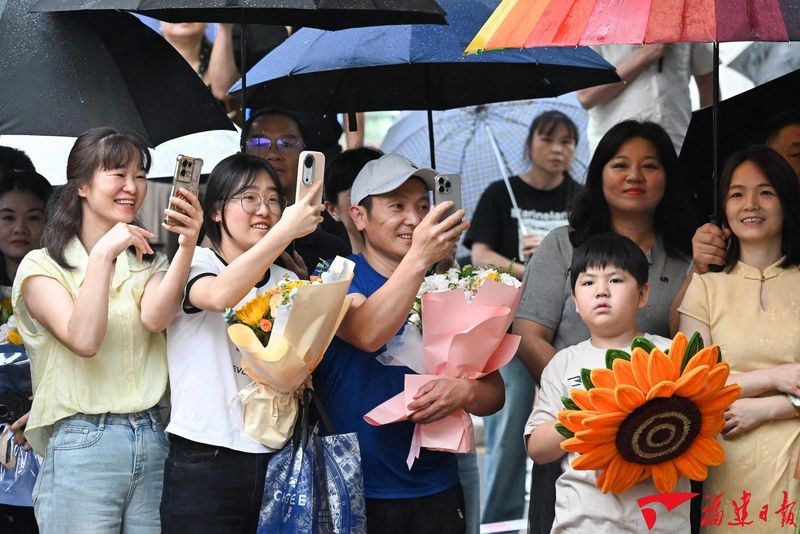 6月9日，福州屏东中学考点外，考生的亲朋好友面带笑容，纷纷举起手机，记录下考生走出考场的瞬间。  本报记者 游庆辉 摄