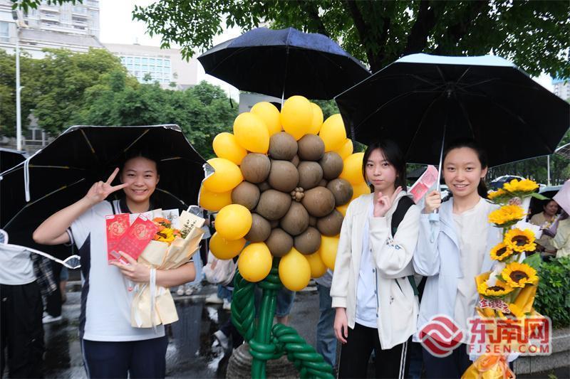 6月9日，福州教育附中考点外，考生在家长准备的巨型“向日葵”花束前拍照。