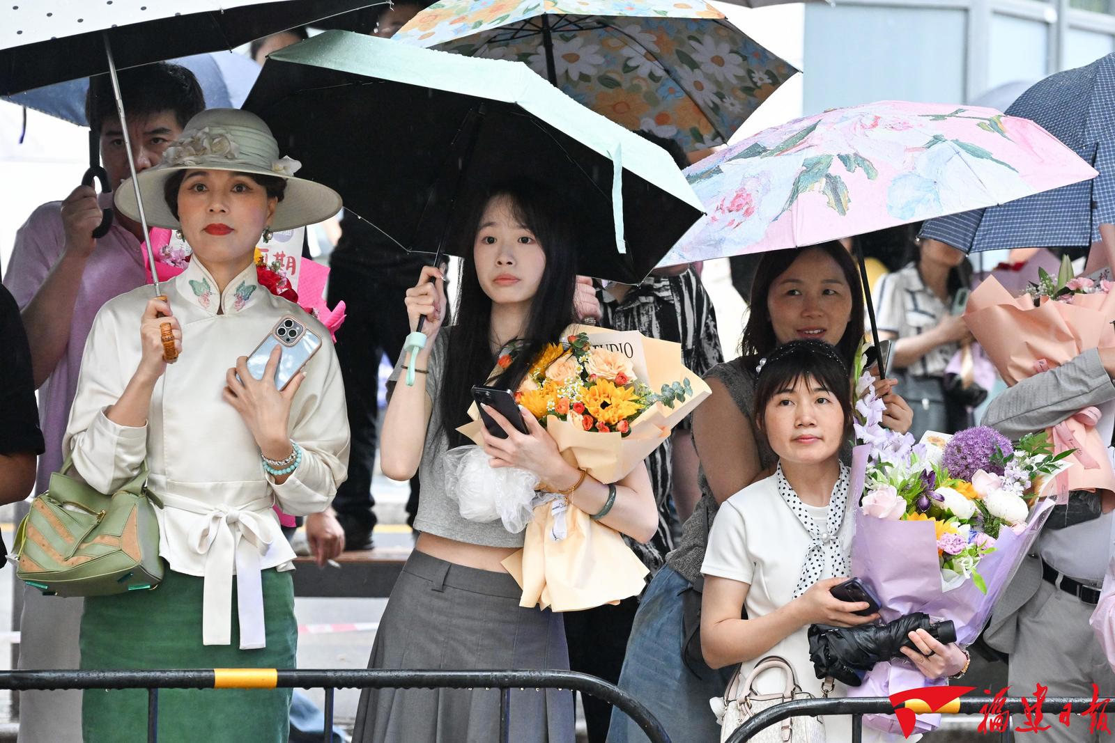 6月9日，福州屏东中学考点外，考生的亲朋好友手捧鲜花、高举横幅、立起易拉宝，满怀期待地等候走出考场的考生。本报记者 游庆辉 摄