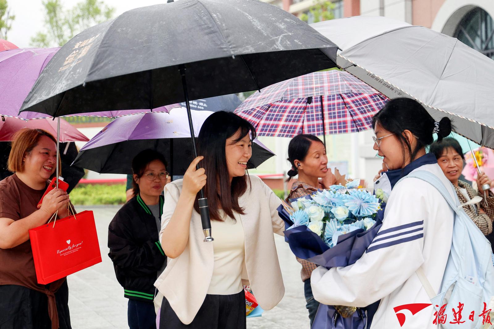 6月9日，随着最后一门考试交卷铃声响起，三明市建宁县第一中学的考生们走出考场，和冒雨前来的家长深情相拥，合影留念。本报记者 庄紫怡 摄